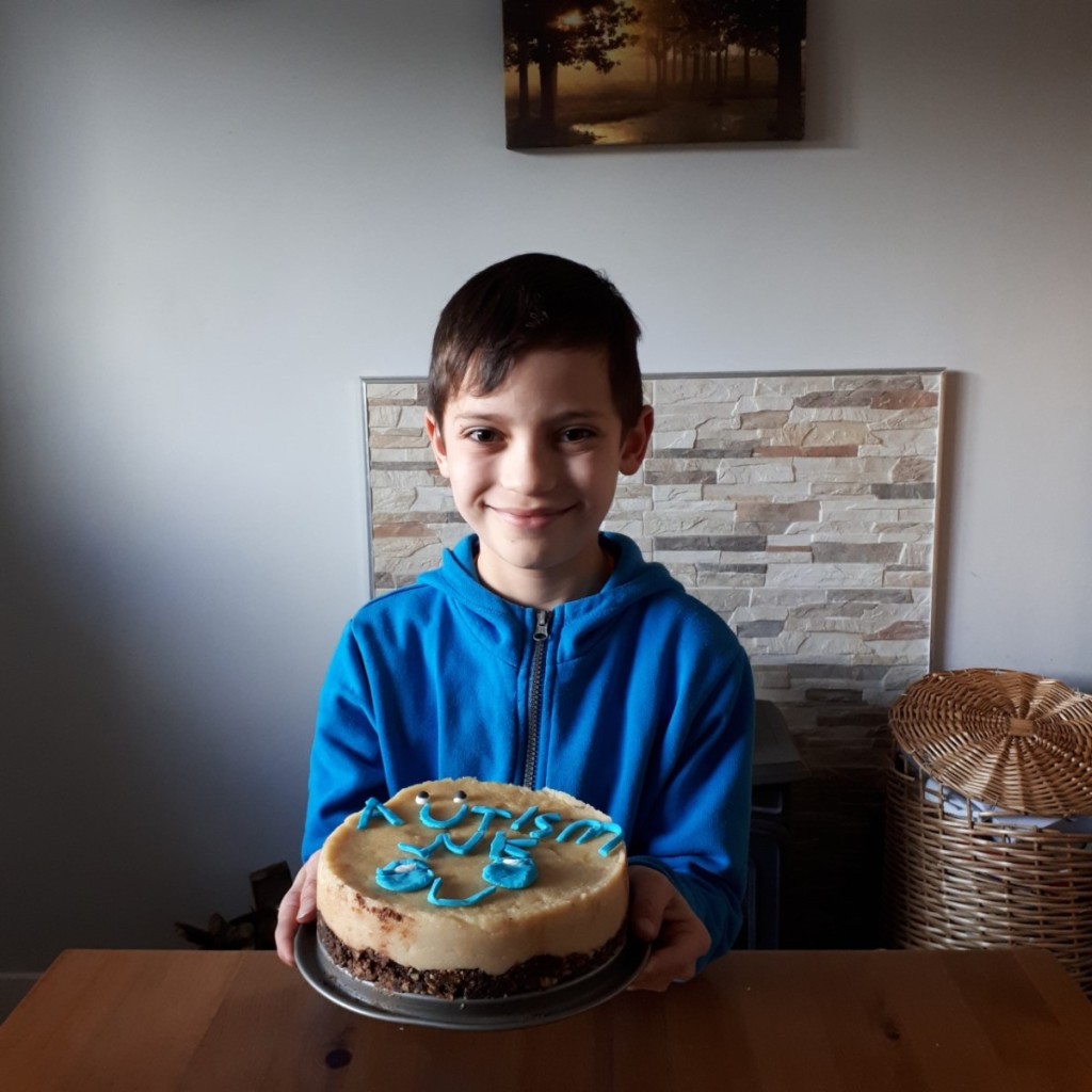 Adam helping bake and design a cake for autism awarness day.